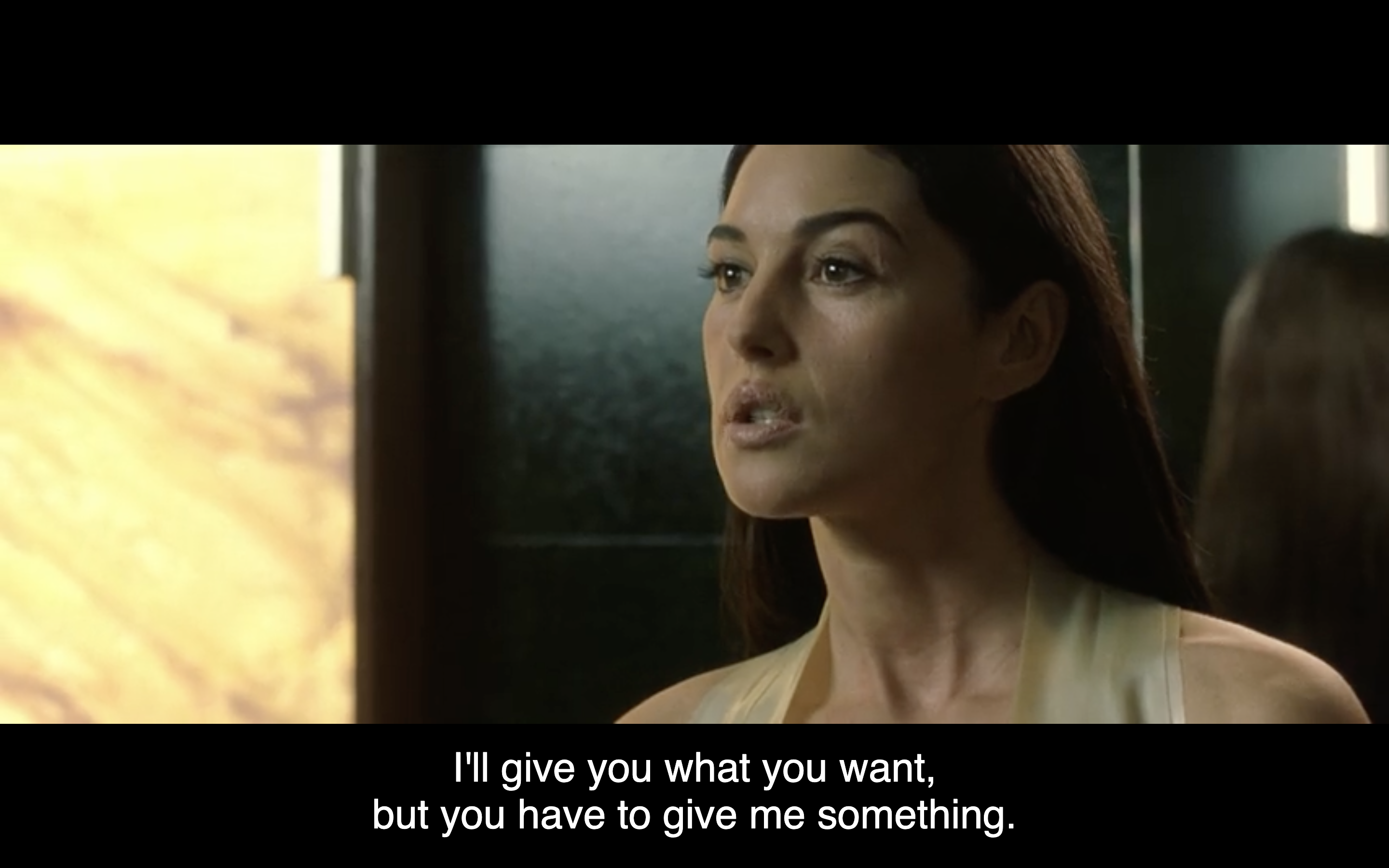 Screenshot of Monica Bellucci, subtitle reads: I'll give you what you want but you have to give me something